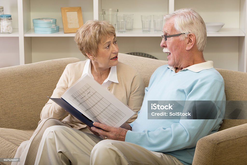 Finacial Problems Senior couple sat at home looking over financial documents 60-64 Years Stock Photo