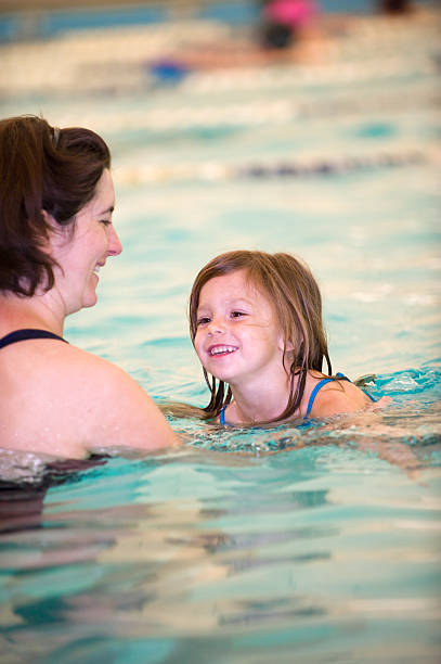 istock Smiling daughter with mother at swim lessons 457530281