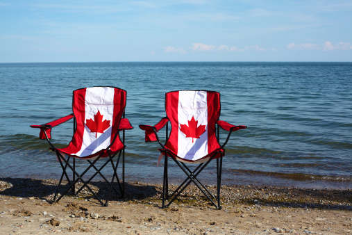 Folding chairs with Canadian flag on them by the lake. Lake Ontario, Canada. Idyllic scene. Summer in Canada. Vacationing in Canada. Canada Day. Lakeshore. Summer. Vacation.