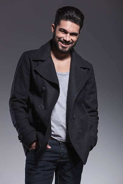 istock young man with long beard in an overcoat smiling 457550423