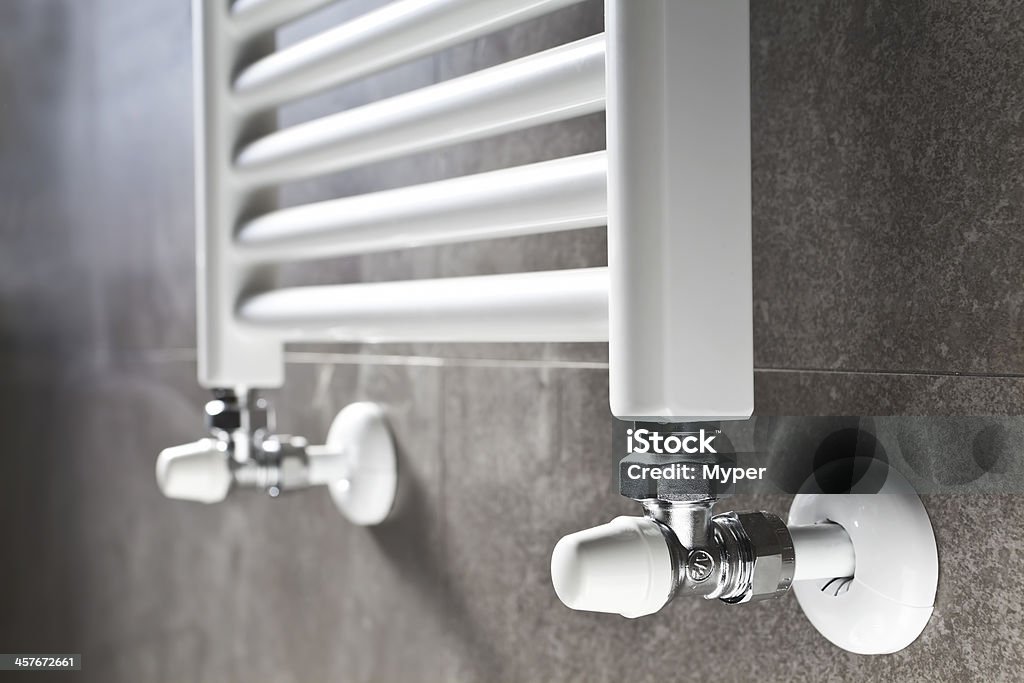 Bathroom heater closeup White bathroom heater closeup on gray wall. Bathroom Stock Photo