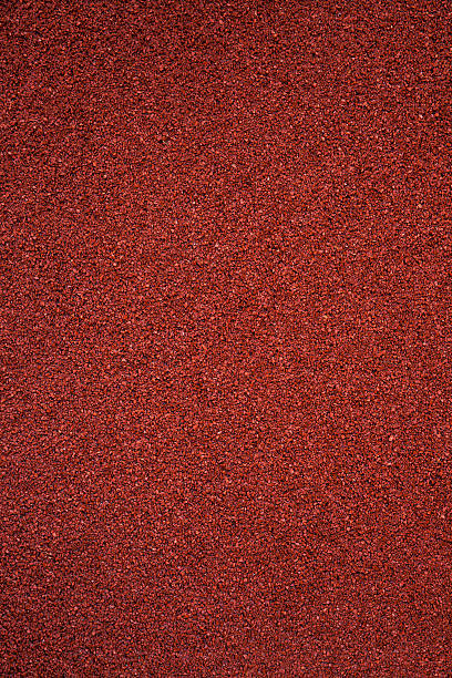 A fresh new red clay running track with rough grip texture