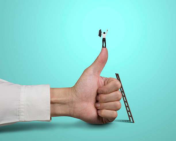istock Businessman standing on top of thumb with 2 hands up 457677595