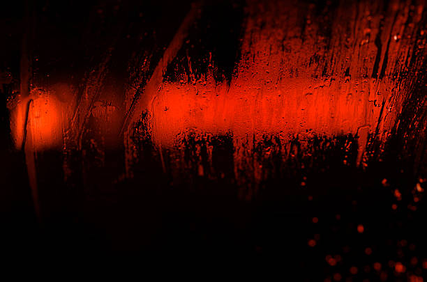 istock red light in the night seen through a wet window 457678459