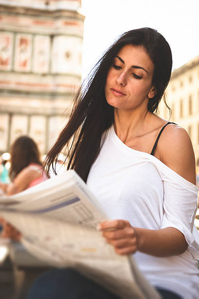 istock Woman reading the newspapers and smiling 457679271