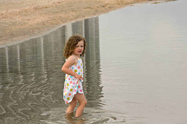 in spiaggia - wading child beach sundress foto e immagini stock