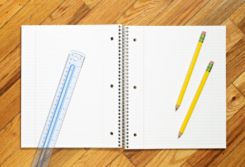 Pencils, ruler and open blank notebook