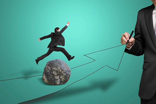 istock Businessman drawing road with arrow, another jumping over rock 457705055