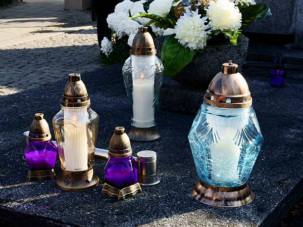 istock burning candels on tomb in cemetery 457706867