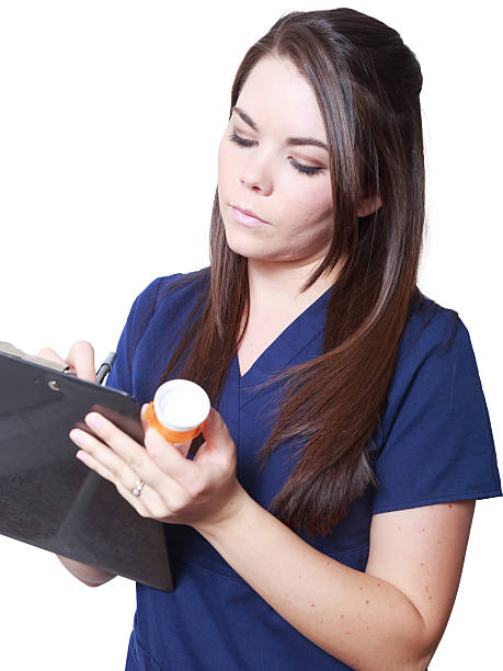 Nurse taking notes holding prescription bottle stock photo