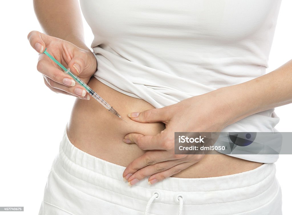 Medical diabetes insulin syringe injection shot Medical diabetes insulin syringe injection shot into abdomen on a white background Abdomen Stock Photo
