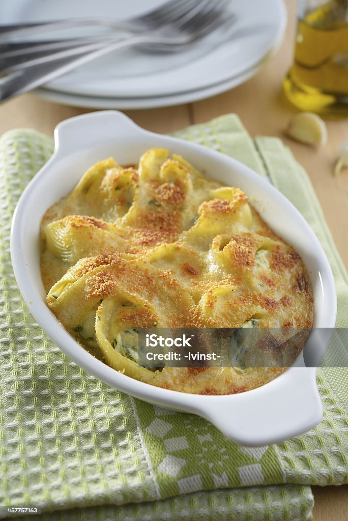 Baked lumaconi with ricotta, spinach, and grated Parmesan cheese Baked Stock Photo
