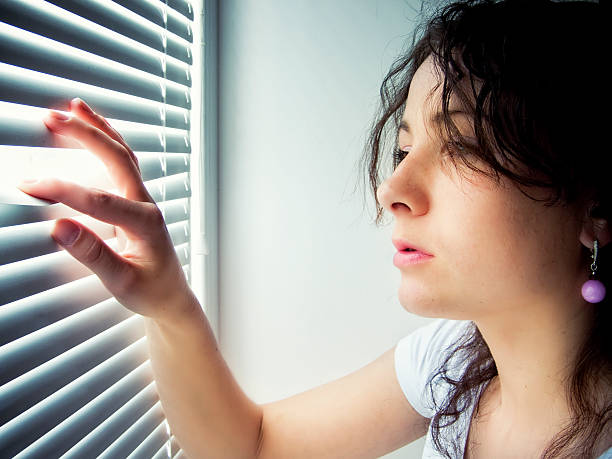 istock Young female is waiting with hope near window 457766837