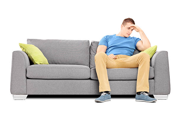 istock Dissappointed young man sitting on a sofa 457774495