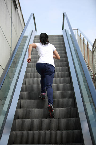mulher correr na escada rolante escadas - railing beautiful human leg people imagens e fotografias de stock