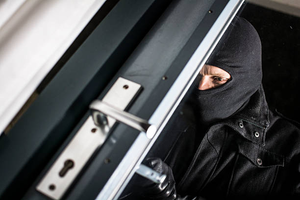 istock A balaclava wearing burglar entering a building 457776299