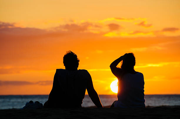 istock Couple watching the sunset on a beach in Maui, Hawaii. 457782933