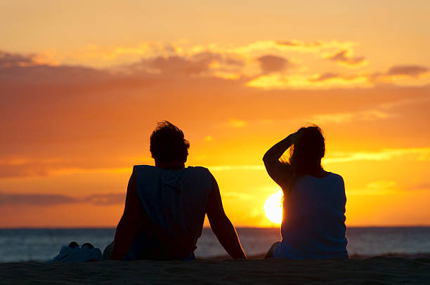 istock Couple watching the sunset on a beach in Maui, Hawaii. 457783749