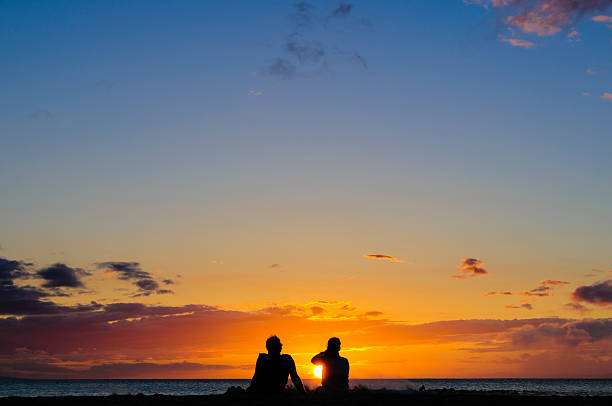istock Couple watching the sunset on a beach in Maui, Hawaii. 457785111