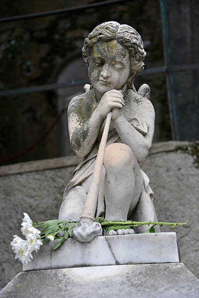 istock Angel on the old graveyard headstone and flowers 457797571