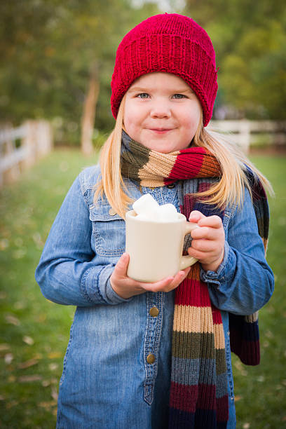 istock Cute Young Girl Holding Cocoa Mug with Marshmallows Outside 457808337