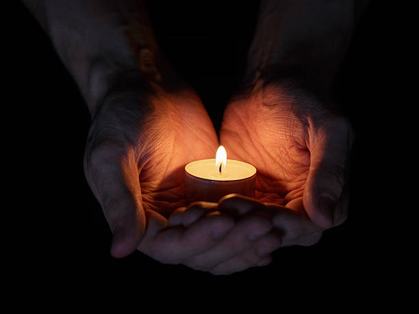 istock adult man hands holding burning candle 457837975