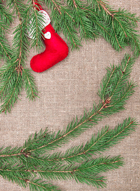 istock Christmas decoration with fir branches and red sock on burlap 457843545