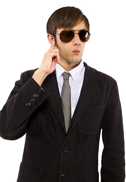 Secret Agent Wearing a Suit and Sun Glasses Providing Security Caucasian male bodyguard wearing sunglasses and black suit mi6 stock pictures, royalty-free photos & images