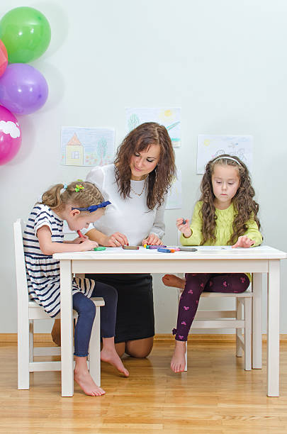 istock Teacher with two girls in kindergarten. 457889949