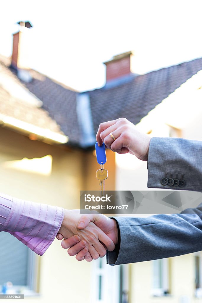 Ausführender Schlüssel in front of house - Lizenzfrei Hände schütteln Stock-Foto