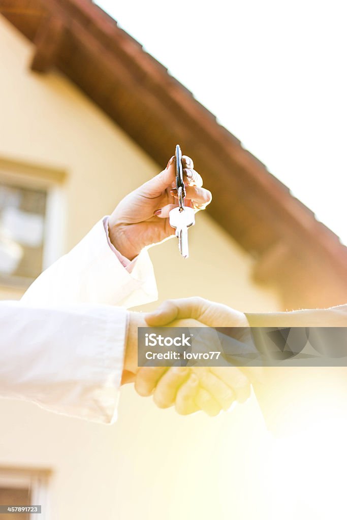 Consegnare le chiavi di casa davanti - Foto stock royalty-free di Stringersi la mano