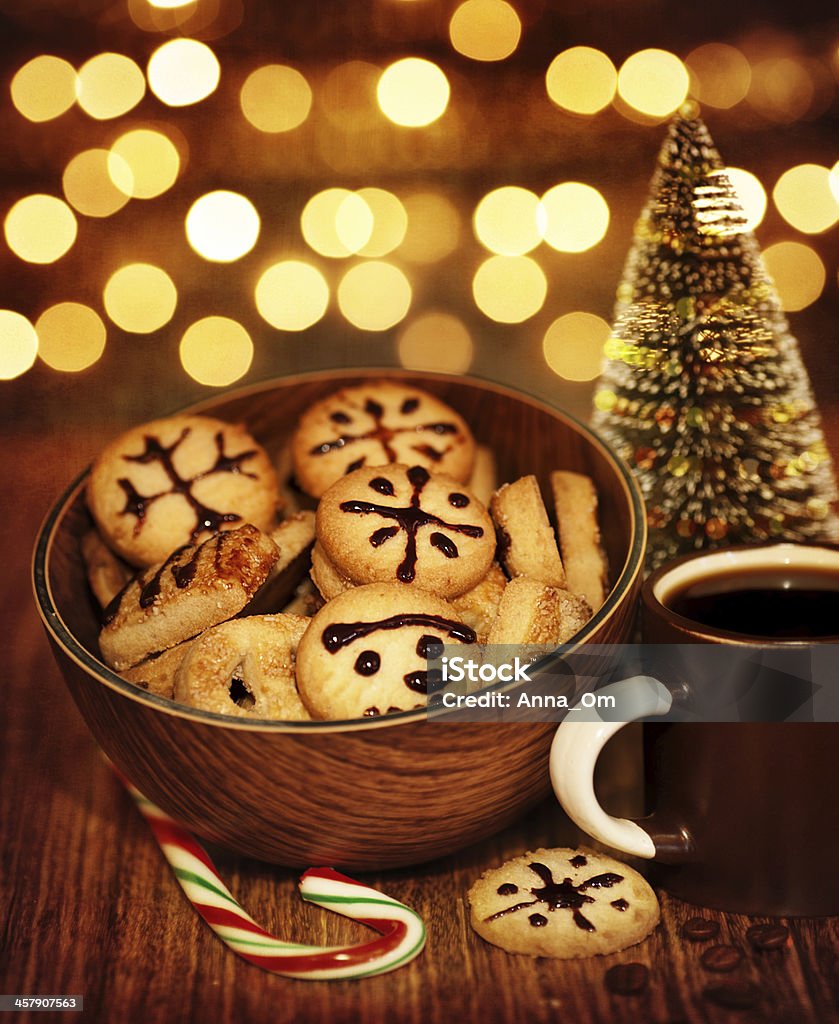 Christmas gingerbread Picture of Christmastime gingerbread with cup of coffee on wooden table, New Year sweets still life on dark glowing brown background, little decorative Christmas tree, candy cane Bread Stock Photo