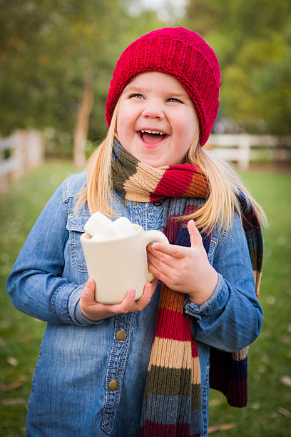 istock Cute Young Girl Holding Cocoa Mug with Marshmallows Outside 457908471