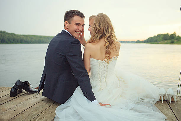 istock Bride with the groom sitting on a pier 457918277