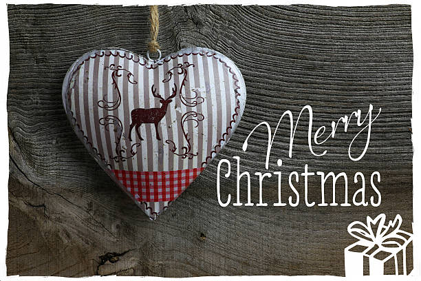Merry Christmas message, handmade decoration deer in tin heart over rustic Elm wood background - retro style design
