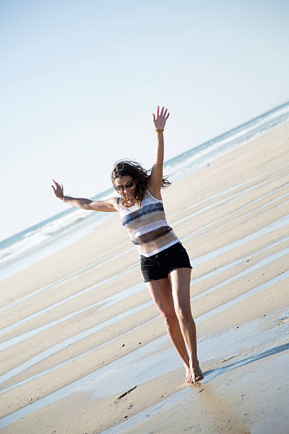 istock Woman With Arms Raised on the Beach 457944371