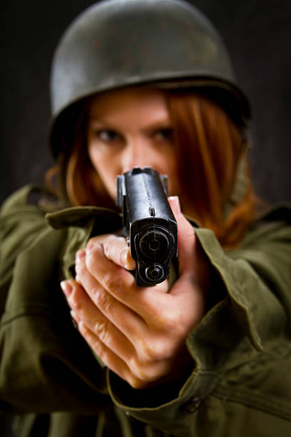 istock Army Girl Pointing Gun 457945243