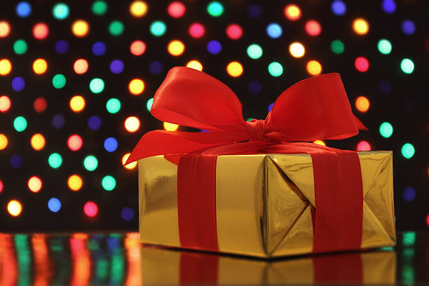 istock Gift wrapped present in front of a festive soft-focus background 457945819