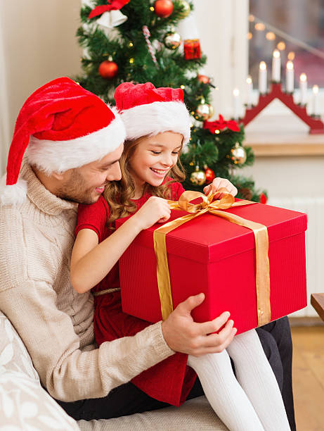istock smiling father and daughter opening gift box 457946917