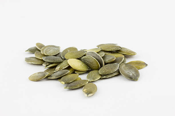 istock Arrangement of pumpkin seeds on a white background 457950659