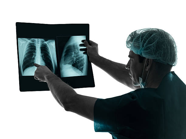 istock doctor surgeon radiologist examining lung torso x-ray image silhouette 457958547