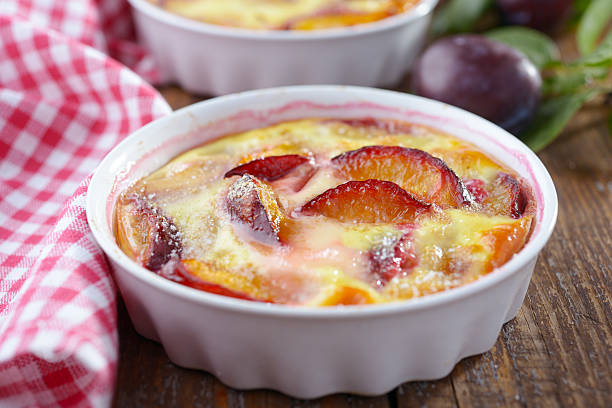 Plum clafoutis in a baking dish Plum clafoutis in a baking dish clafoutis stock pictures, royalty-free photos & images