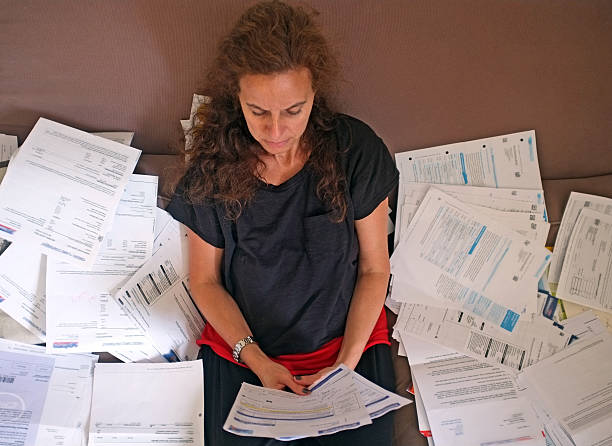 istock A woman surrounded by billing statements looking upset 457960147