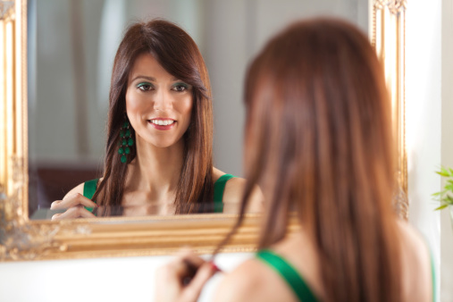 Content adult woman looking at her reflection in a mirror.