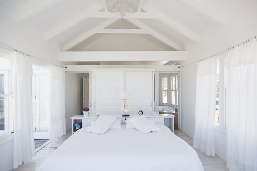 Rafters above bed in white bedroom