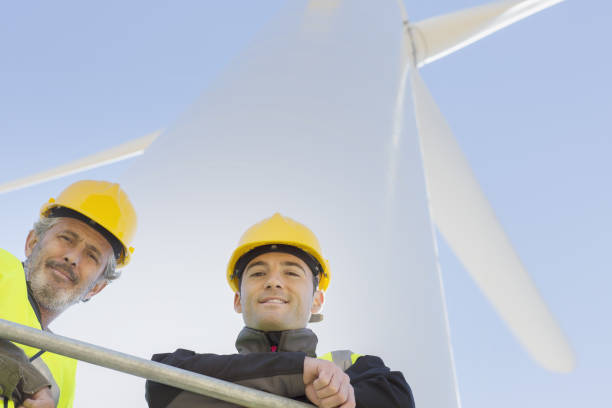istock Workers standing on wind turbine in rural landscape 457977801