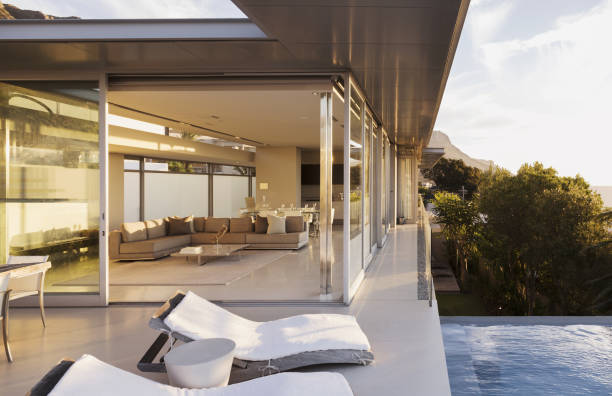 istock Lounge chairs at poolside of modern house 457977969