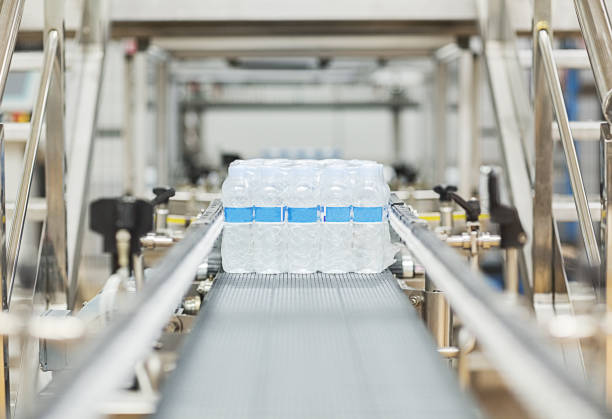 water bottles on conveyor belt in factory - conveyor belt fotos imagens e fotografias de stock