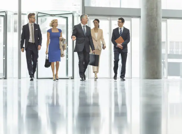 Photo of Business people walking in office