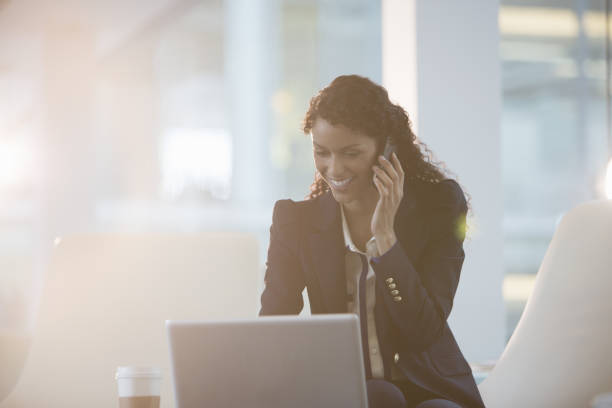 istock Businesswoman using laptop and cell phone in office 457979217